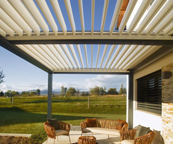 Bioklimatska pergola Misteral na prostorni terasi, s prilagodljivimi lamelami za optimalno zaščito pred soncem in dežjem.